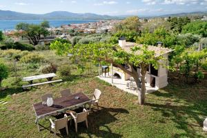 a picnic table and chairs in a garden with a view at Villa Ermina Paleros in Paleros