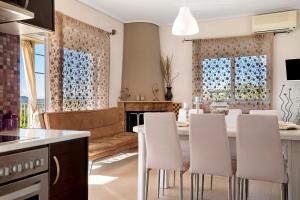 a kitchen and living room with a table and chairs at Villa Ermina Paleros in Paleros +23 photos