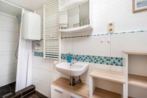 a bathroom with a sink and a mirror at Ferienwohung Marion - Hohnstein in Rathewalde +14 photos