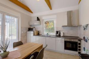 a kitchen with white cabinets and a wooden table at Lifestyle Ferienhaus in Pouch