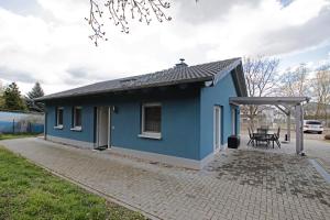 a small blue house with a table and a picnic table at Lifestyle Ferienhaus in Pouch