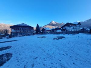 a field covered in snow with buildings in the background at Cœur des neiges in Bernex