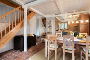 a kitchen and dining room with a wooden table and chairs at Haus am alten Deich in Rodenäs
