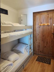 a room with two bunk beds and a door at Cœur des neiges in Bernex