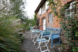 two blue chairs and a table in front of a building at Haus am alten Deich in Rodenäs