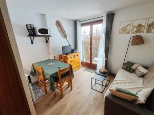 a living room with a table and a couch at Cœur des neiges in Bernex