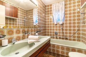 a bathroom with a tub and a sink at Ferienhaus Burghalde mit Sauna in Alpirsbach +29 photos
