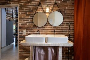a bathroom with two sinks and two mirrors on a brick wall at Villa La Fenière in Payzac +9 photos