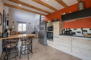 a kitchen with orange walls and wooden countertops at Villa La Fenière in Payzac
