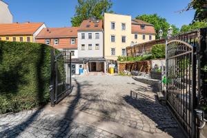 a gate to a courtyard with buildings in the background at Ferienhaus1856de mit Sauna in Görlitz