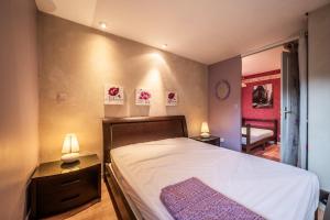 a bedroom with a bed and two lamps and a couch at Appartement Bernex - 3 personnes in Bernex