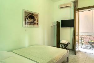 a bedroom with a bed in a room with a balcony at Old Boat double studio 2 in Nikiana