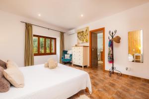 a bedroom with a white bed and a dresser at Casa Hermosa in Capdepera +22 photos