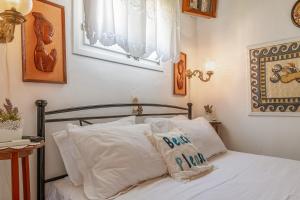 a bedroom with a bed with white sheets and pillows at Penny 's House in Artemonas