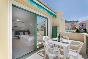a balcony with a table and chairs and a bedroom at Mareverde K130 in Adeje