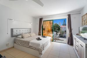 a white bedroom with a bed and a balcony at Mareverde K130 in Adeje +15 photos
