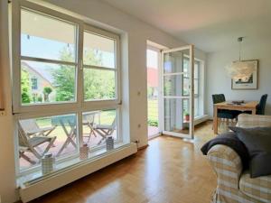 a living room with a couch and a large window at Komfort-Ferienwohnung am See in Bodman-Ludwigshafen +12 photos