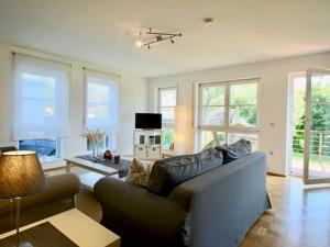 a living room with a couch and a table at Komfort-Ferienwohnung am See in Bodman-Ludwigshafen