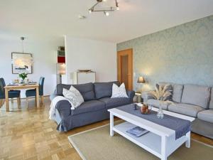 a living room with a couch and a table at Komfort-Ferienwohnung am See in Bodman-Ludwigshafen