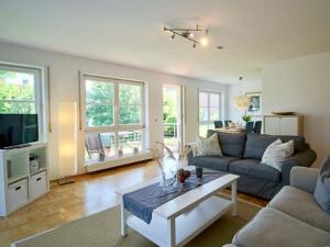a living room with a couch and a table at Komfort-Ferienwohnung am See in Bodman-Ludwigshafen