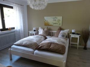 a bedroom with a bed with pillows and a chandelier at Haus Wiesengrund in Forbach