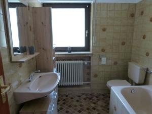 a bathroom with two sinks and a tub and a toilet at Haus Wiesengrund in Forbach +22 photos