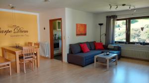 a living room with a blue couch and a table at Haus Wiesengrund in Forbach