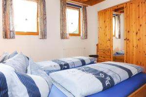 two beds in a room with two windows at Wellehof in Oberkirch