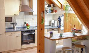 a kitchen with a stove and a counter with stools at Wellehof in Oberkirch