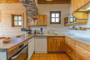 a kitchen with wooden cabinets and a counter top at Chalet La Darse Nature et Sérénité in Villard-Reculas