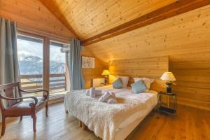 a bedroom with a bed and a large window at Chalet La Darse Nature et Sérénité in Villard-Reculas