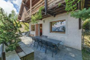 a patio with a table and chairs in front of a house at Chalet La Darse Nature et Sérénité in Villard-Reculas