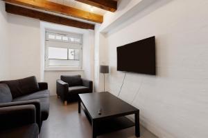 a living room with a couch and a tv on a wall at Villa Arena in Geisingen