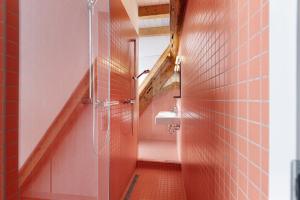 a bathroom with pink tile walls and a toilet at Villa Arena in Geisingen +37 photos
