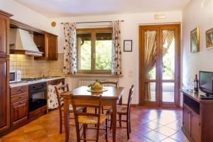 a kitchen with a wooden table and chairs and a dining room at Bilo Hedera in Marina di Grosseto