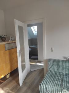 a bedroom with a bed and a door leading to a bathroom at Sachsen Rosie in Hartmannsdorf