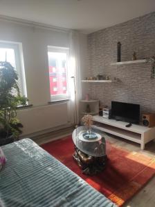 a living room with a coffee table and a tv at Sachsen Rosie in Hartmannsdorf