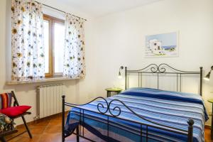 a bedroom with a bed and a chair and a window at Bilo Hedera in Marina di Grosseto +20 photos
