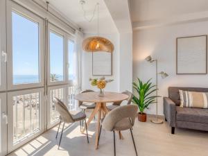 a living room with a table and chairs and a couch at Hanami Avenida de España Oceanfront in Estepona