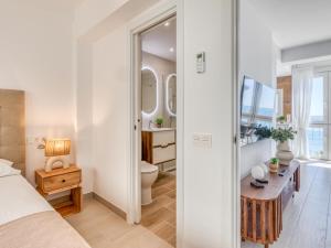 a bedroom with a bed and a bathroom with a toilet at Hanami Avenida de España Oceanfront in Estepona