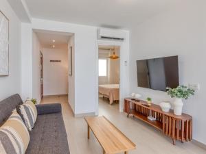 a living room with a couch and a tv at Hanami Avenida de España Oceanfront in Estepona