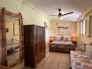 a bedroom with a bed and a large wooden cabinet at Gufo in Pitigliano