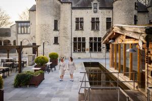 two women standing in front of a building at Thermae Boetfort Hotel in Steenokkerzeel
