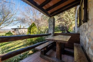 a wooden bench on the porch of a house at Gufo in Pitigliano