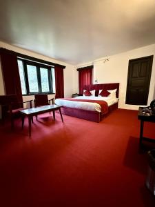 a hotel room with a bed and a table at Riverdale by Stay Pattern in Pahalgām