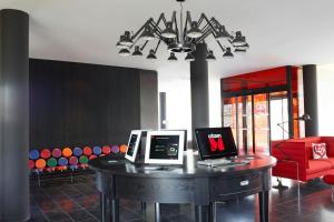 a room with a table with two computers on it at citizenM Paris Charles de Gaulle Airport in Roissy-en-France