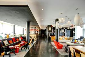 a lobby with couches and chairs in a building at citizenM Paris Charles de Gaulle Airport in Roissy-en-France