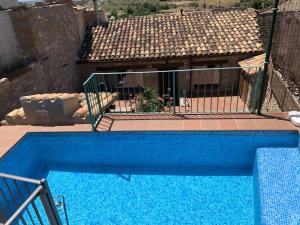 a blue swimming pool in front of a house at Casabras Rural in Claravalls