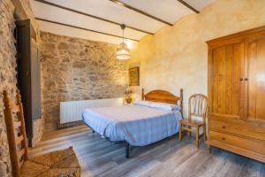 a bedroom with a bed and a chair in a room at Casabras Rural in Claravalls +31 photos