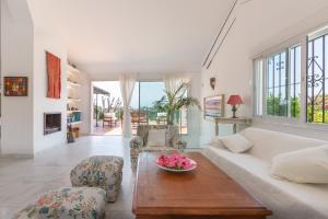 a living room with a couch and a bowl of flowers on a table at Almijan Alegria in Estepona